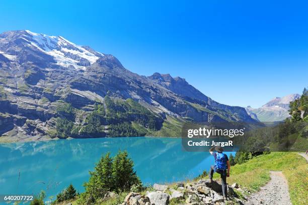homme randonneur admirant les paysages de montagne dans les alpes suisses - lac-oeschinensee photos et images de collection