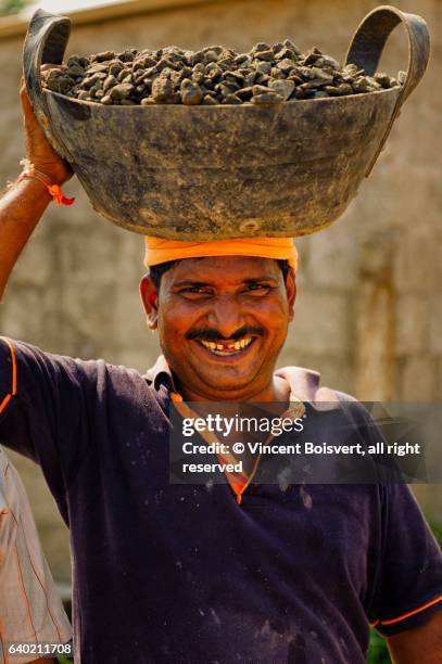 carrying heavy loads of stone, alleppey, india - sourire à pleines dents stock-fotos und bilder