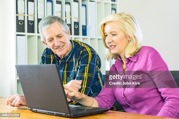 senior businesswoman with older businessman and office computer - nail file stock pictures, royalty-free photos & images