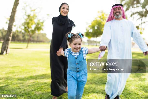 glücksfamilie zu fuß im park in saudi-arabien - saudi youth stock-fotos und bilder