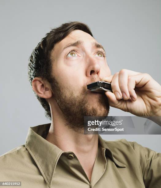 close-up of man playing harmonica - harmonica stock pictures, royalty-free photos & images