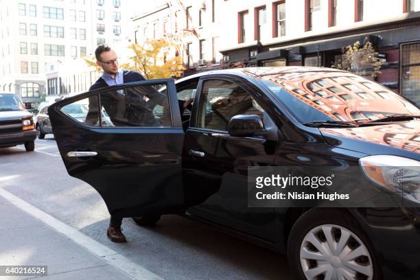 man getting into car - entering stock pictures, royalty-free photos & images