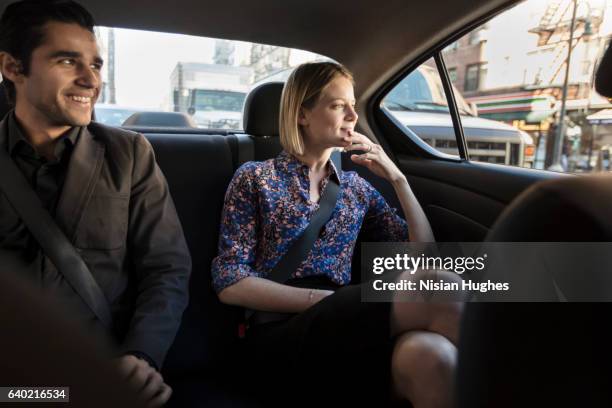 young couple sitting in car - car back seat stock pictures, royalty-free photos & images
