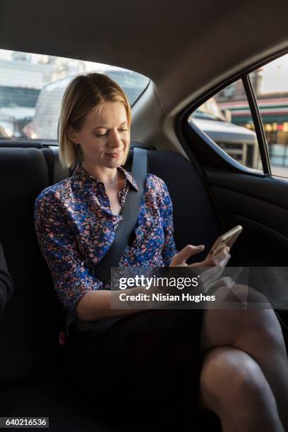 woman sitting in car - management car smartphone stock pictures, royalty-free photos & images