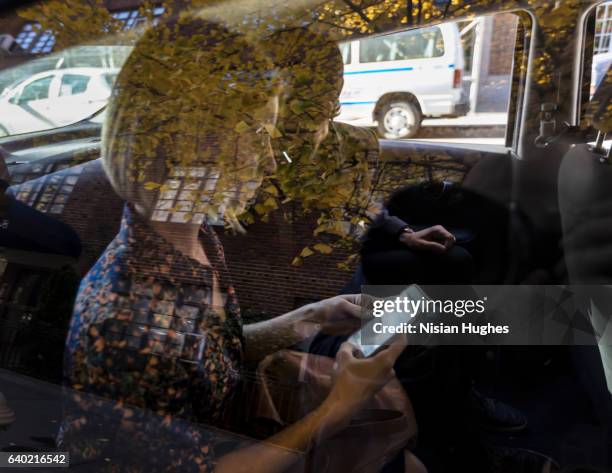 man and woman sitting in car, view through window - management car smartphone stock-fotos und bilder