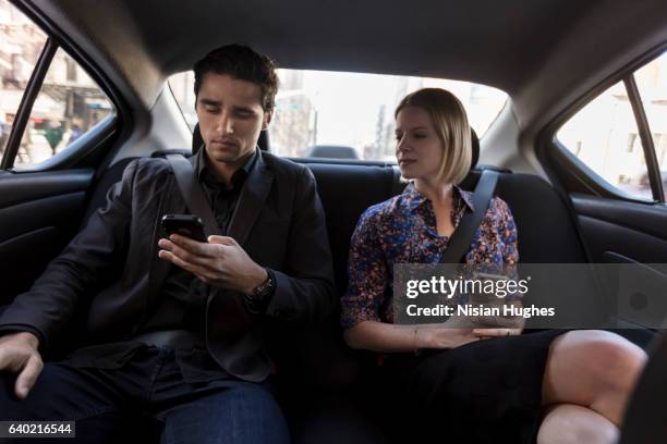 young couple sitting in car on phones - management car smartphone stock pictures, royalty-free photos & images