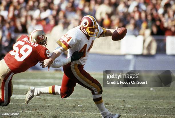 Washington, D.C. Running back John Riggins of the Washington Redskins runs through the tackle of Willie Harper of the San Francisco 49ers during an...