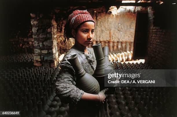 Young girl and containers in a potters' workshop, Cairo, Egypt.