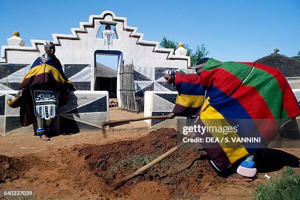 Men mixing clay in a Ndebele village, South Africa.