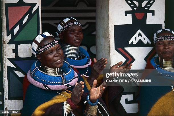 Ndebele women wearing traditional costumes and idzilla, bronze or copper neck rings, Ndebele village, Botshabelo township, Transvaal, South Africa.