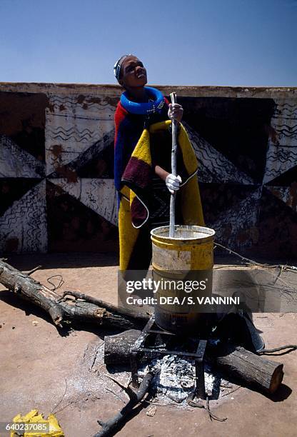 Ndebele woman preparing colours for painting murals in the village, Botshabelo township, Transvaal, South Africa.