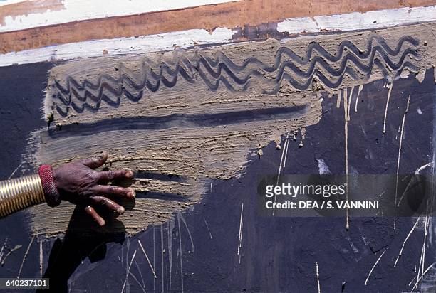 Ndebele woman decorating a village wall, Botshabelo township, Transvaal, South Africa.