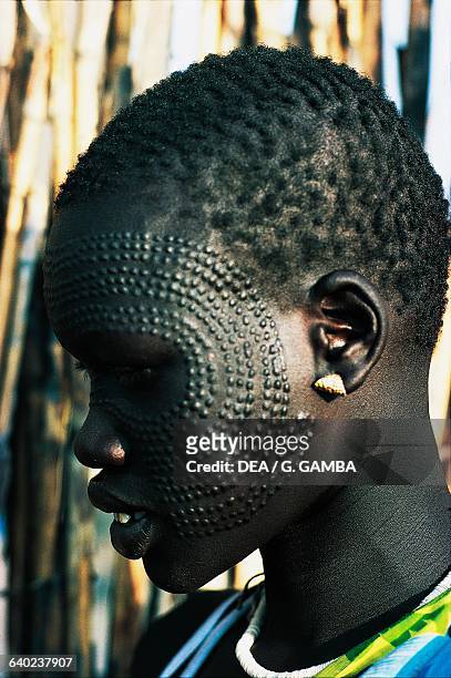Young Nuer woman with ornamental scarification on her face, South Sudan.