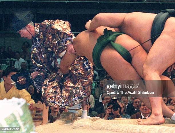 Referee Shikimori Inosuke is pushed out during a bout between Mongolian Kyokushuzan and Takanohana during day five of the Grand Sumo Spring...