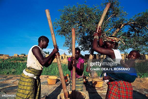 Women pounding millet in a mortar, Dogon Sangha village, Bandiagara Escarpment, Mali.