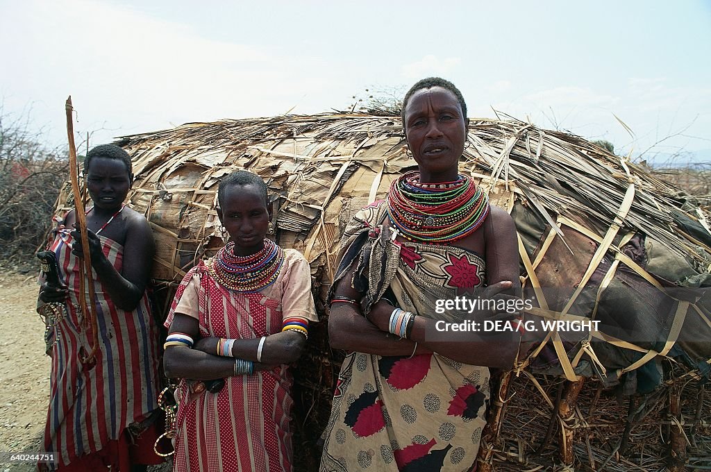 Samburu women in front of a thatched hut