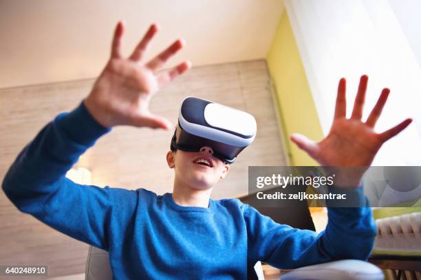 faszinierter kleiner junge mit vr virtual reality - vr cardboard stock-fotos und bilder