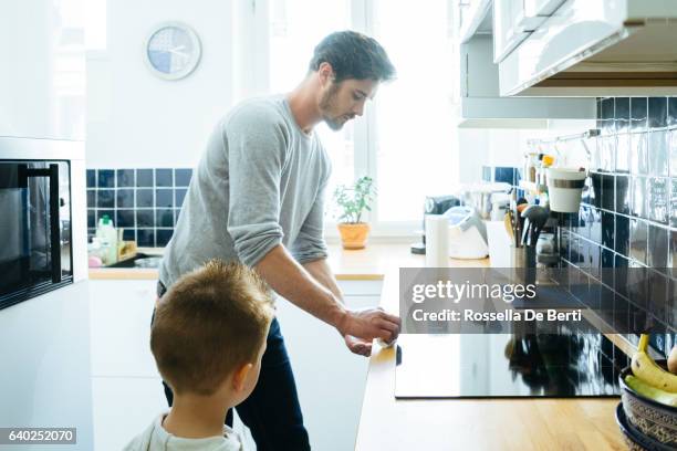 father cleaning up the kitchen after breakfast - kitchen mop stock pictures, royalty-free photos & images