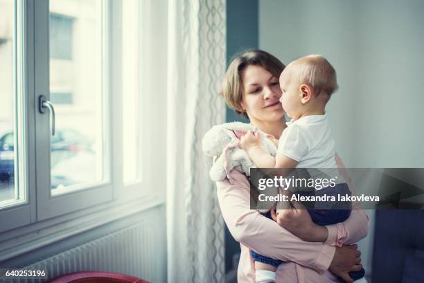 mother with her child at home - iakovleva stock pictures, royalty-free photos & images