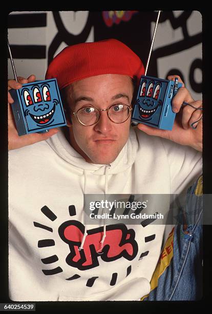 Artist Keith Haring holds two radios he designed at his Pop Shop.