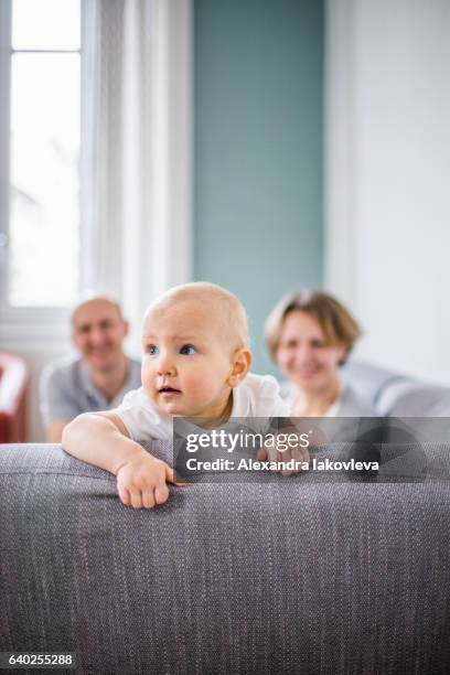 toddler girl at home with parents at the background - alexandra iakovleva stock pictures, royalty-free photos & images