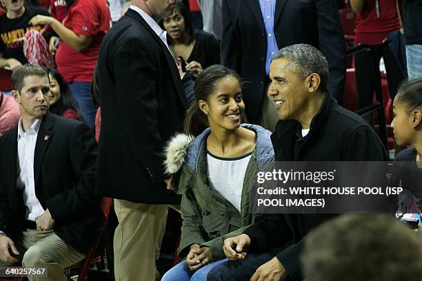 President Barack Obama talks with daughter Malia Obama as they attend a men's NCCA basketball between University of Maryland and Oregon State...