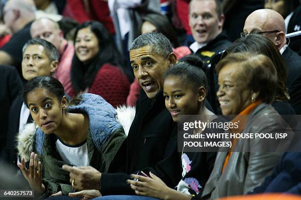 From L to R, daughter Malia Obama, President Barack Obama, Sasha Obama and Marian Robinson attend a men's NCCA basketball between University of...