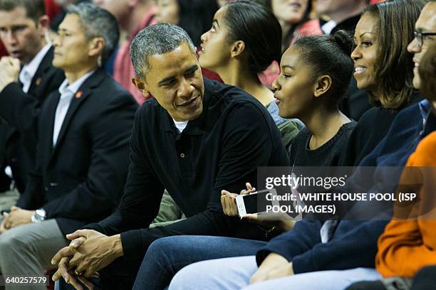 From L to R, daughter Malia Obama, President Barack Obama, Sasha Obama and First Lady Michelle Obama attend a men's NCCA basketball between...