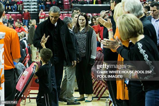 President Barack Obama high fives a boy as he arrives at a men's NCCA basketball between University of Maryland and Oregon State University, November...