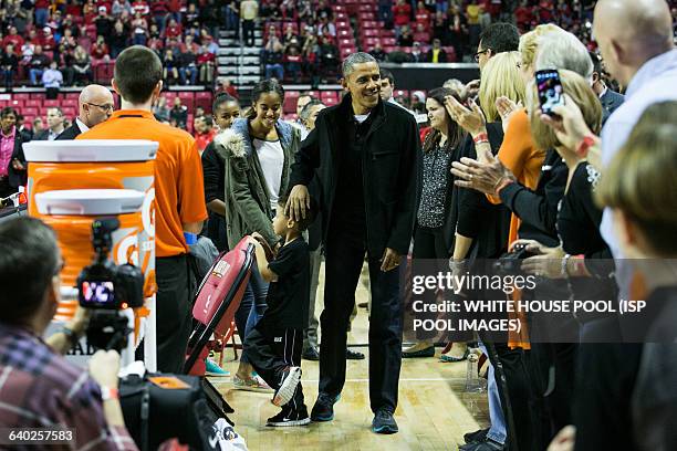 President Barack Obama rubs a boy's head as he arrives at a men's NCCA basketball between University of Maryland and Oregon State University,...