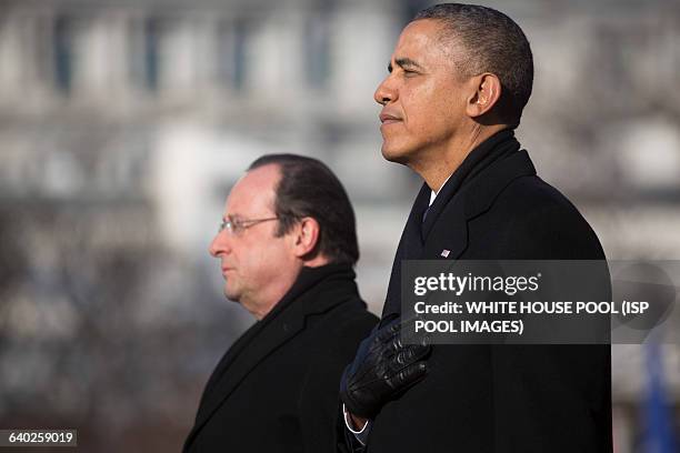 President Barack Obama, right, and Francois Hollande, France's president, listen to the national anthems during an arrival ceremony on the South Lawn...