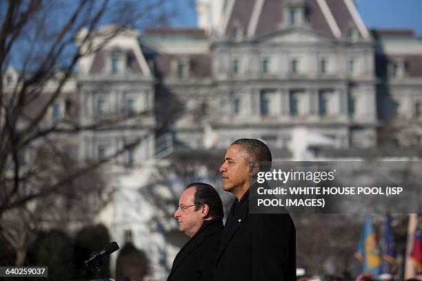 President Barack Obama, right, and Francois Hollande, France's president, listen to the national anthems during an arrival ceremony on the South Lawn...