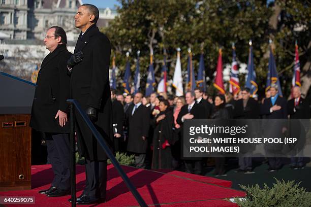 President Barack Obama, right, and Francois Hollande, France's president, listen to the national anthems during an arrival ceremony on the South Lawn...