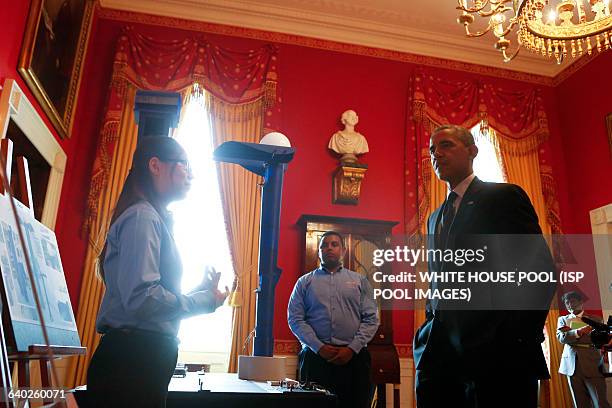 President Barack Obama looks at the Pedestrian crossing signal project from Felege Gebru and Karen Fan during the 2014 White House Science Fair at...