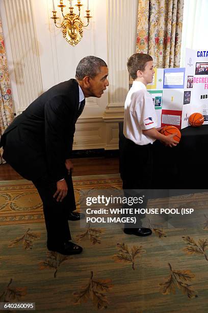 President Barack Obama catches a ball from the "Basketball Catapult" a science project of Brooke Bohn , Daisjaughn Bass and Gerry McManus , from...