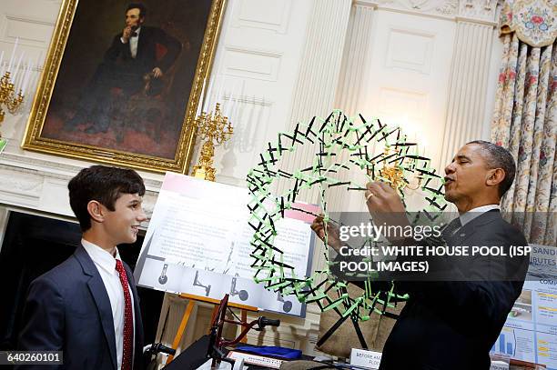 President Barack Obama looks at the project of Peyton Roberston from Ft Lauderdale, FL, winner of the Discovery 3M Young Scientist, for his "Sandless...