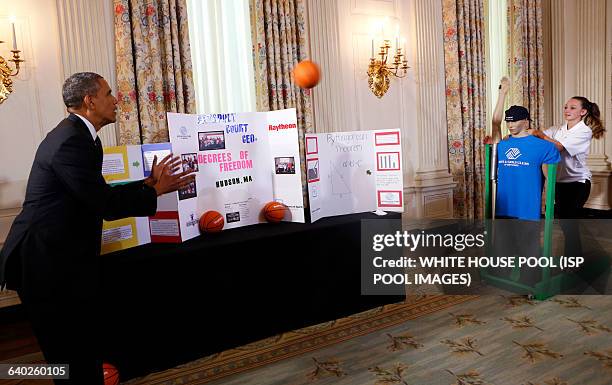 President Barack Obama catches a ball from the "Basketball Catapult" a science project of Brooke Bohn , Daisjaughn Bass and Gerry McManus , from...