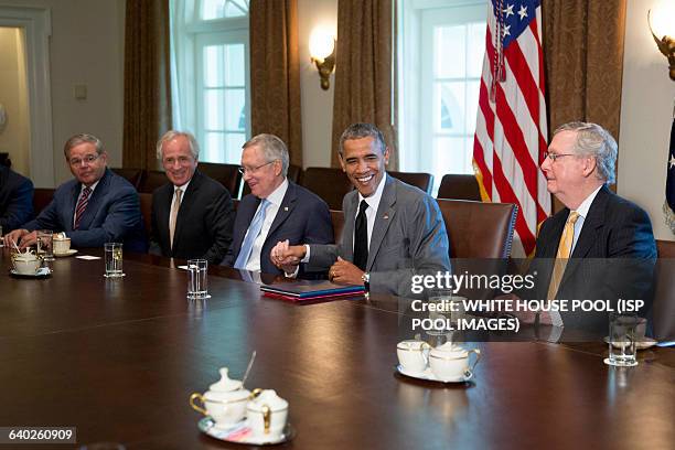 President Barack Obama, second from right, shakes hands with Senate Majority Leader Harry Reid, a Democrat from Nevada, during a meeting with members...