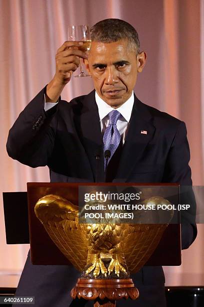 President Barack Obama raises a glass and toasts his guests during a dinner on the occassion of the U.S.-Africa Leaders Summit on the South Lawn of...