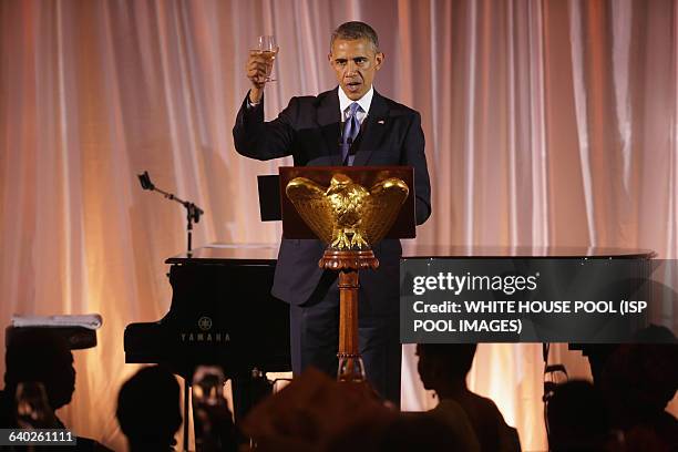 President Barack Obama raises a glass and toasts his guests during a dinner on the occassion of the U.S.-Africa Leaders Summit on the South Lawn of...