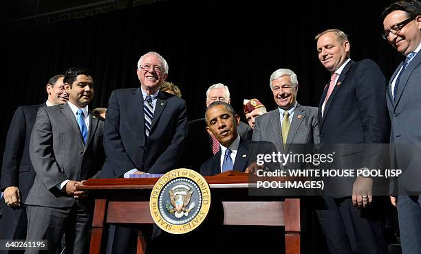 President Barack Obama, surrounded by congressmen and veteran's officials, signs HR 3230, The Veterans' Access to Care through Choice, Accountability...