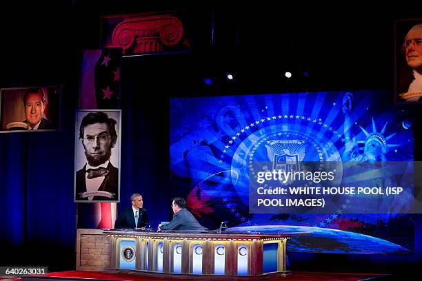 President Barack Obama, left, tapes Comedy Central's "The Colbert Report" with television personality Stephen Colbert in Lisner Auditorium at George...