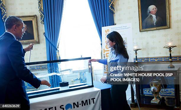 Us President Barack Obama looks at the generator of Corine Peifer and Kristian Sonsteby from Wallenpaupack, PA that use the movement of a boat dock...