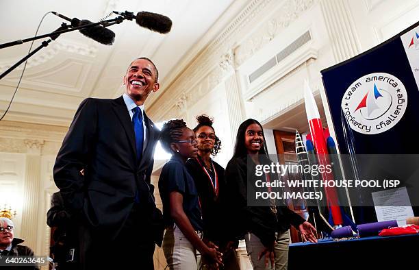 Us President Barack Obama listens to Stephanie Bullock who is part of a team from the US Virgin Islands that design rockets for the Team America...