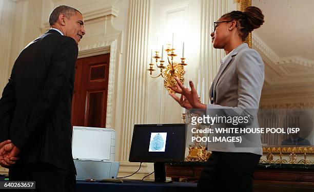 Us President Barack Obama listens to Sophia Sanchez-Maes from Las Cruces, New Mexico, who identified a form of Yellowstone algae that could turn...
