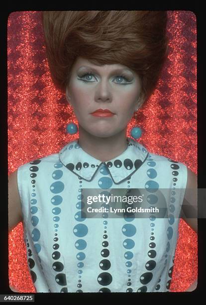 Studio portrait of one of the female members of the rock group, the B-52's. She is wearing a 1960's dress, complete with beehive. Undated.