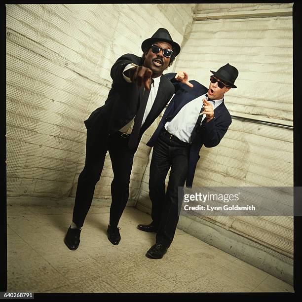 Dan Aykroyd, dressed as Elwood Blues from the movie The Blues Brothers, dances with singer Sam Moore.