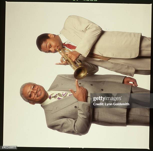 Portrait of father Ellis Marsalis pointing to his son Wynton playing trumpet.