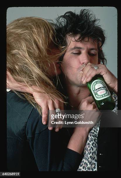 Rolling Stones rock star Keith Richards drinks a Heineken beer and hugs his spouse, model Patti Hansen.