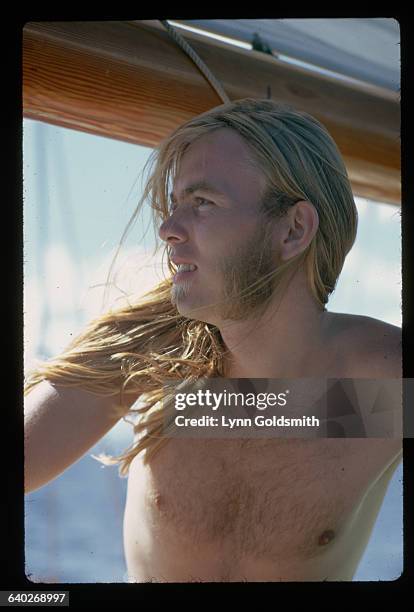 Outdoor Gregg Allmann. He is shown shirtless, in a head and shoulders view, standing aboard a boat. Photograph, 1987.
